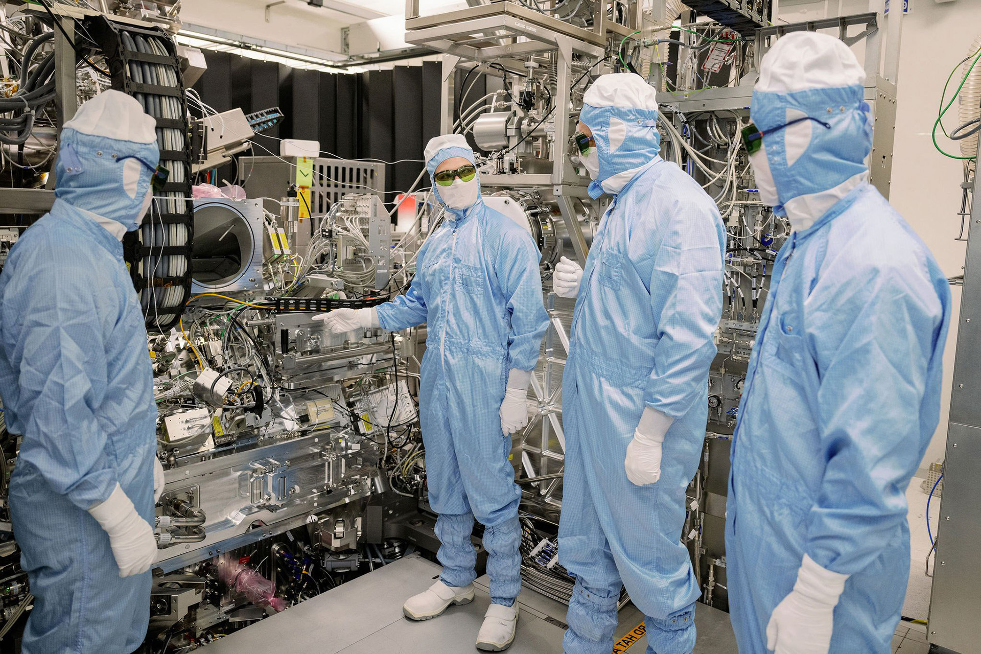 ASML technicians examining a machine part in a cleanroom 